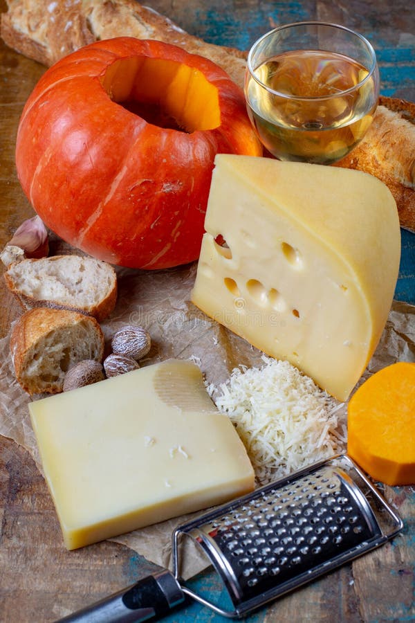 Ingrediens для традиционного сезонного швейцарского блюда, фондю тыквы с сырами gruyer и emmentaler, белого вина, свежего creme и стоковые фотографии rf Ingrediens для традиционного сезонного швейцарского блюда, фондю тыквы с сырами gruyer и emmentaler, белого вина, свежего creme и стоковые фотографии rf