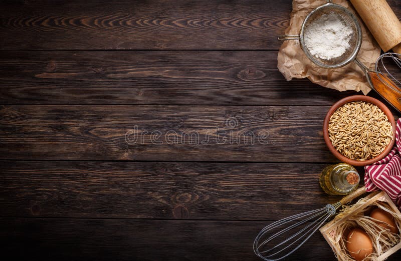 Ingredienser för att baka på tom mörk träbakgrund arkivbild Ingredienser för att baka på tom mörk träbakgrund arkivbild