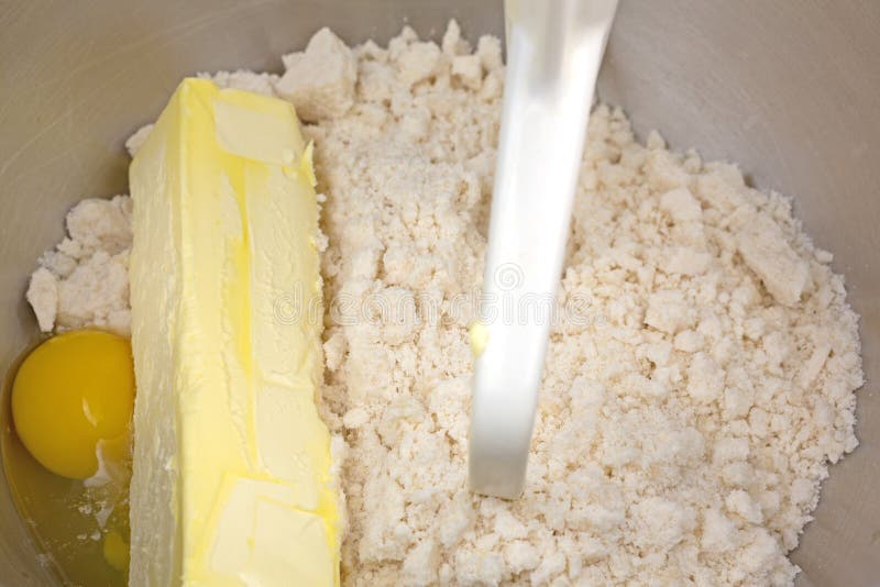 Ingredienser för deg för sockerkaka i plastbunke arkivbild Ingredienser för deg för sockerkaka i plastbunke arkivbild