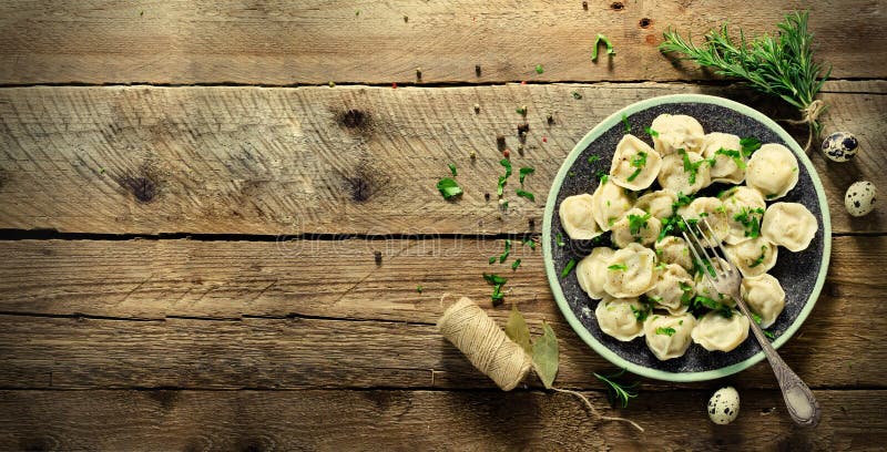 Ingredienser för framställning av pelmenien, ravioli, klimpar - deg, rosmarin, kavel, kanfastråd, smör, lagerblad överkant arkivfoto