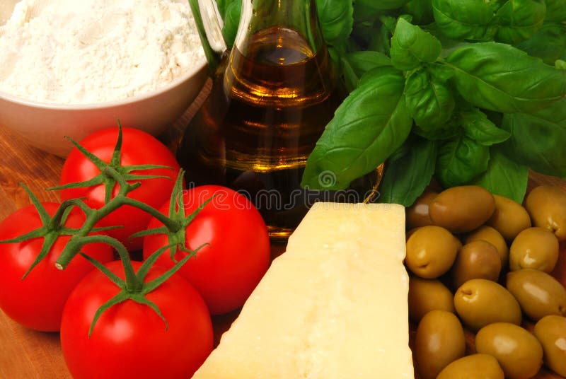 Ingredients for an Italian meal: tomatoes, basil, olive oil, flour and parmesan cheese. Ingredients for an Italian meal: tomatoes, basil, olive oil, flour and parmesan cheese