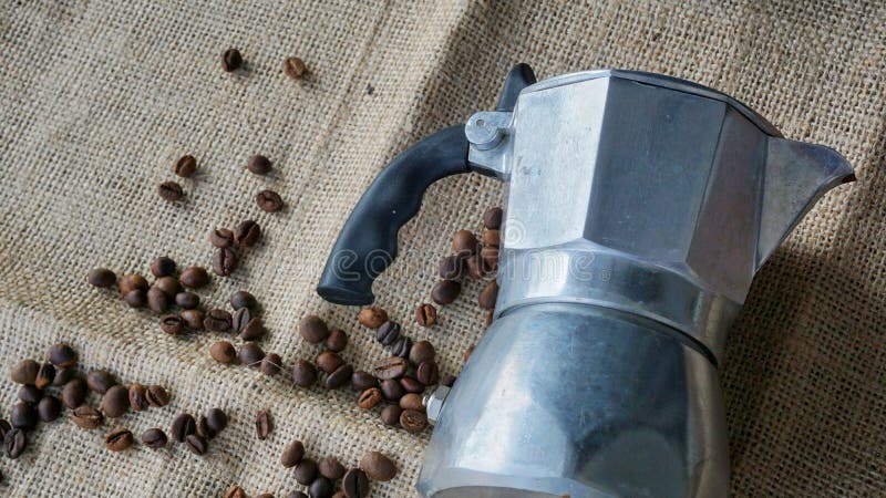 Ingrediente per la fabbricazione del caffè di moka. vaso di moka con chicchi di caffè sullo sfondo di canapa. concetto di fabbrica
