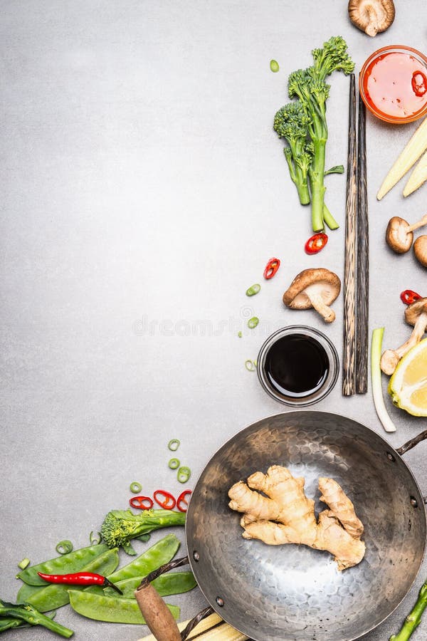 Ingredientes da fritada da agitação com frigideira chinesa e hashis Culinária asiática que cozinha ingredientes no fundo de pedra foto de stock royalty free Ingredientes da fritada da agitação com frigideira chinesa e hashis Culinária asiática que cozinha ingredientes no fundo de pedra foto de stock royalty free