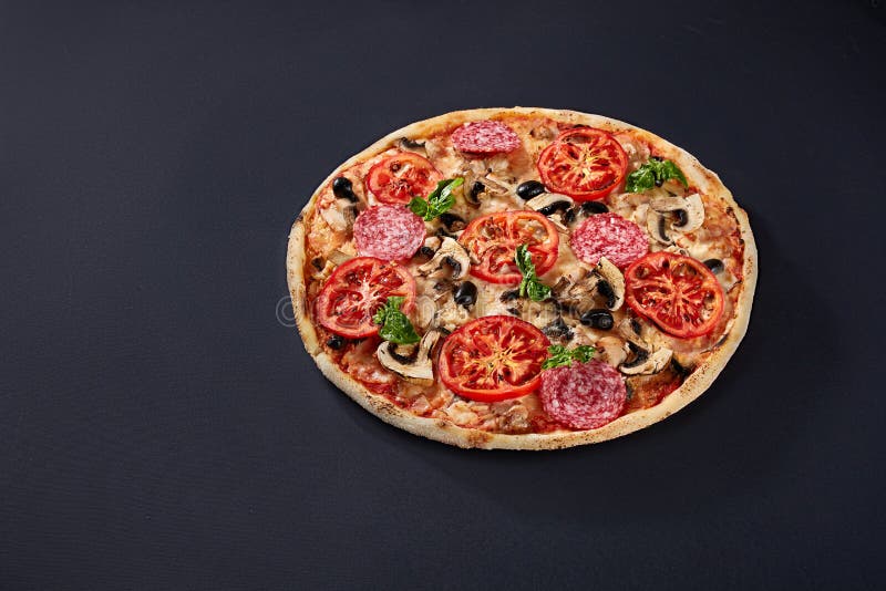 Ingredientes de alimento e especiarias para cozinhar e pizza italiana deliciosa no fundo concreto preto imagens de stock Ingredientes de alimento e especiarias para cozinhar e pizza italiana deliciosa no fundo concreto preto imagens de stock