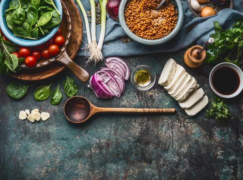 Ingredientes do vegetariano para pratos saborosos da lentilha no fundo rústico da mesa de cozinha com cozimento da colher e dos u