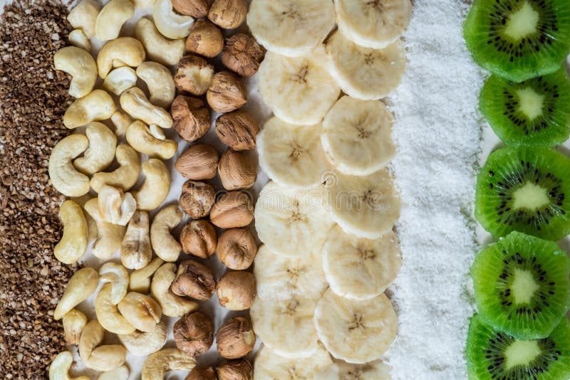 Ingredientes frescos para um quivi cru saudável do café da manhã do alimento, os flocos do coco, os cajus e as avelã disparados d imagens de stock Ingredientes frescos para um quivi cru saudável do café da manhã do alimento, os flocos do coco, os cajus e as avelã disparados d imagens de stock