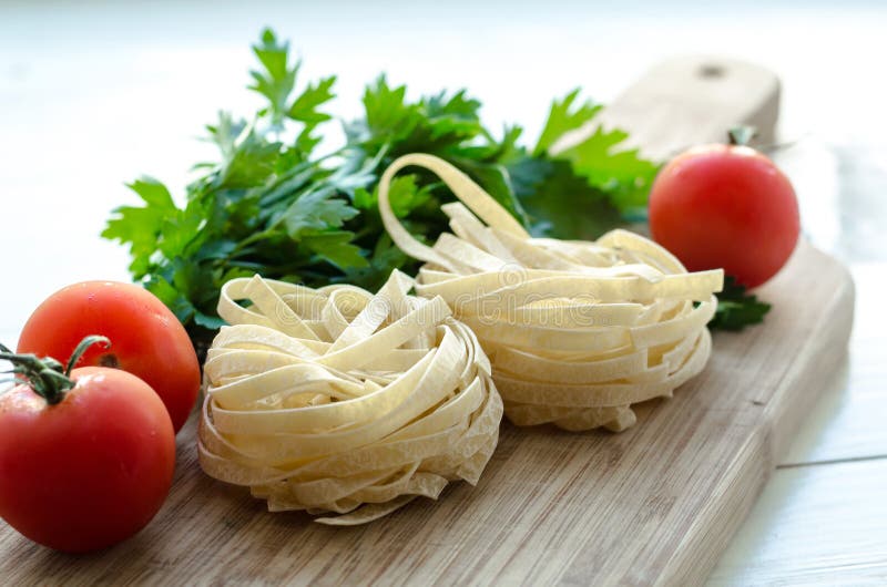 Ingredientes para cozinhar a massa italiana - espaguete, tomates, manjericão e alho foto de stock Ingredientes para cozinhar a massa italiana - espaguete, tomates, manjericão e alho foto de stock