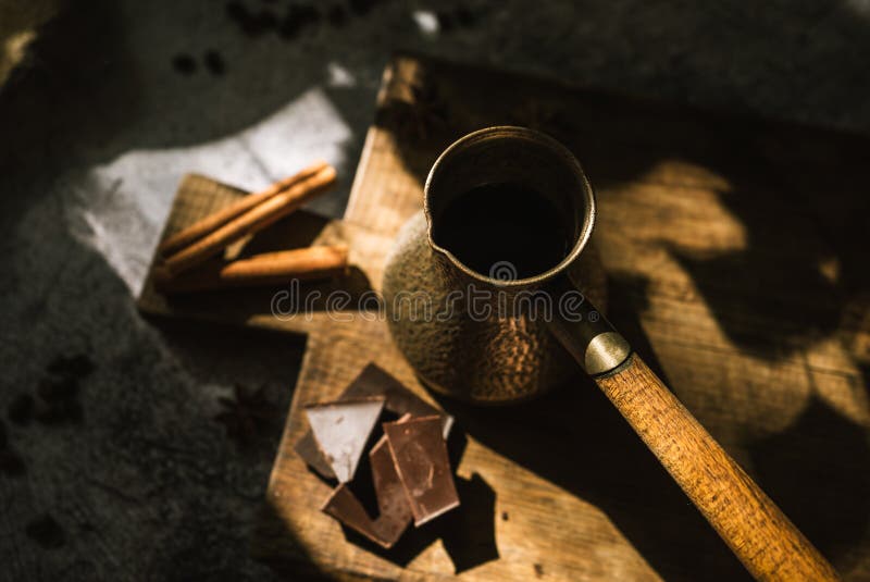 Ingredients for making coffee, cinnamon, chocolate, spices on a brown wooden board. Ingredients for making coffee, cinnamon, chocolate, spices on a brown wooden board