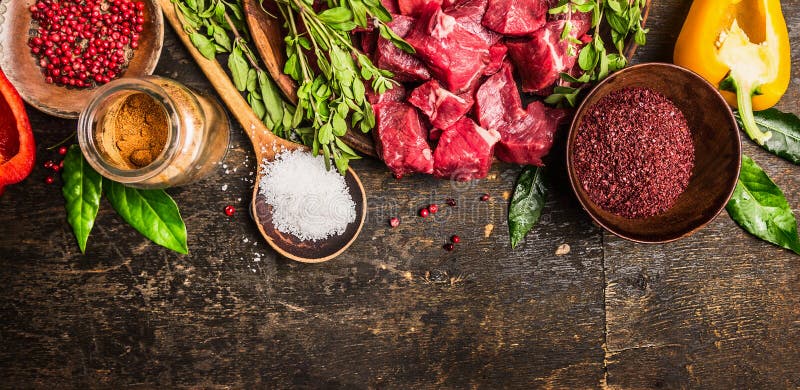 Ingredientes para o cozimento da goulash ou do guisado: carne crua, ervas, especiarias, vegetais e colher do sal no fundo de made