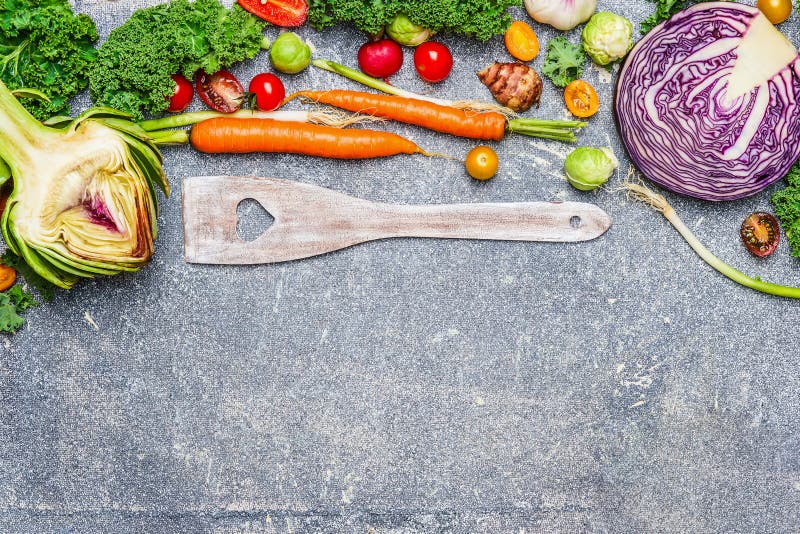 Ingredienti degli ortaggi freschi e cucchiaio di cottura di legno con cuore su fondo rustico grigio, vista superiore fotografia stock Ingredienti degli ortaggi freschi e cucchiaio di cottura di legno con cuore su fondo rustico grigio, vista superiore fotografia stock