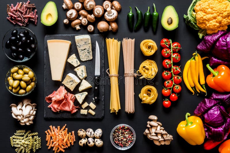 Ingredienti freschi differenti per la cottura pasta, gli spaghetti, fettuccine, fusilli e delle verdure italiani sul nero fotografie stock libere da diritti Ingredienti freschi differenti per la cottura pasta, gli spaghetti, fettuccine, fusilli e delle verdure italiani sul nero fotografie stock libere da diritti