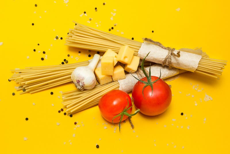 Ingredienti italiani della pasta su un fondo giallo, vista superiore fotografia stock Ingredienti italiani della pasta su un fondo giallo, vista superiore fotografia stock