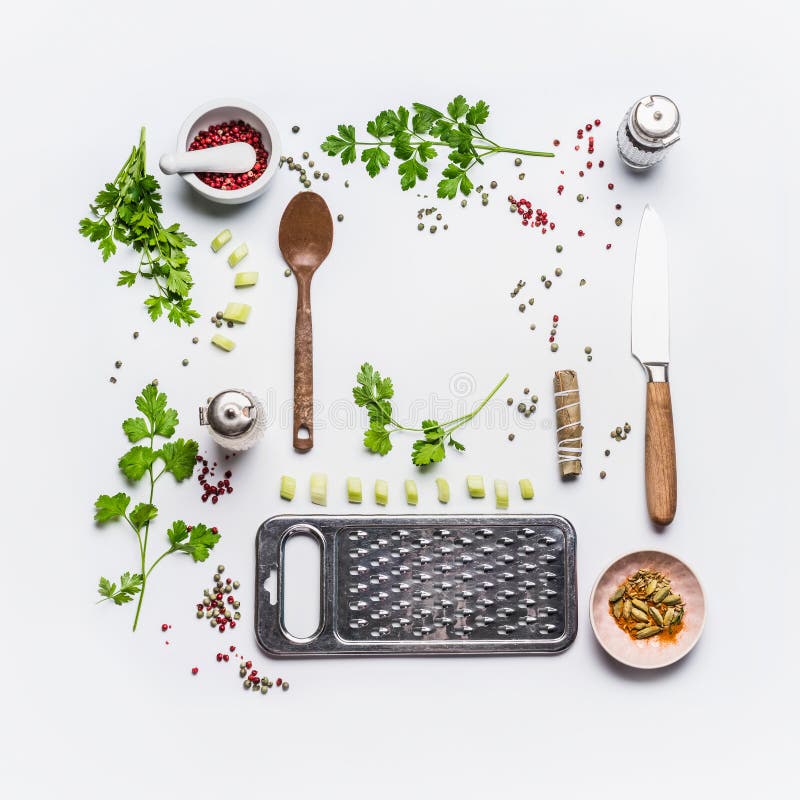 Ingredienti mangianti e di condimenti sani per la cottura saporita con il cucchiaio ed il coltello su fondo bianco, vista superio