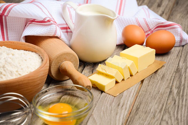 Ingredients for baking - milk, butter, eggs and flour. Rustic background. Horizontal permission. Selective focus. Ingredients for baking - milk, butter, eggs and flour. Rustic background. Horizontal permission. Selective focus.