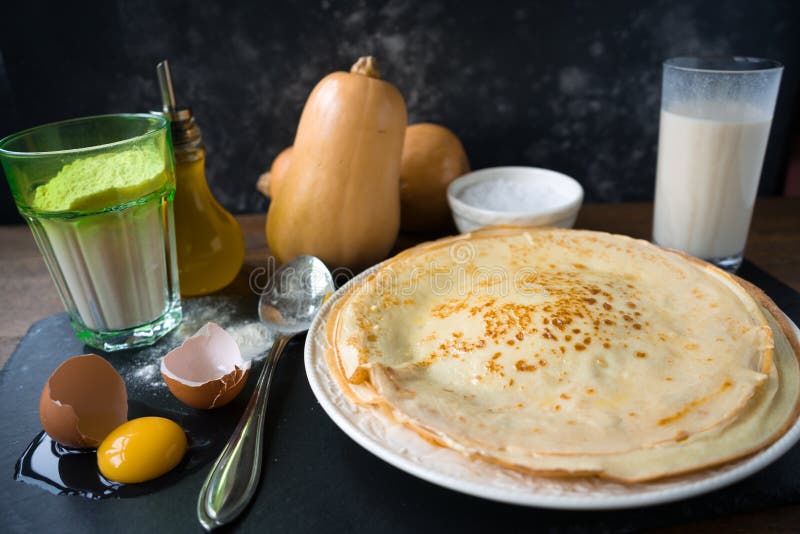 Ingredienti per produrre i pancake - uovo, burro, latte, zucchero e stile rustico o rurale crudo della pasta, immagine stock Ingredienti per produrre i pancake - uovo, burro, latte, zucchero e stile rustico o rurale crudo della pasta, immagine stock