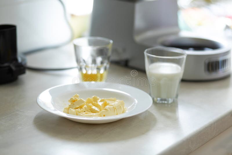 Ingredients for Making Sweet Cream. Butter Melts in a Plate Stock Image