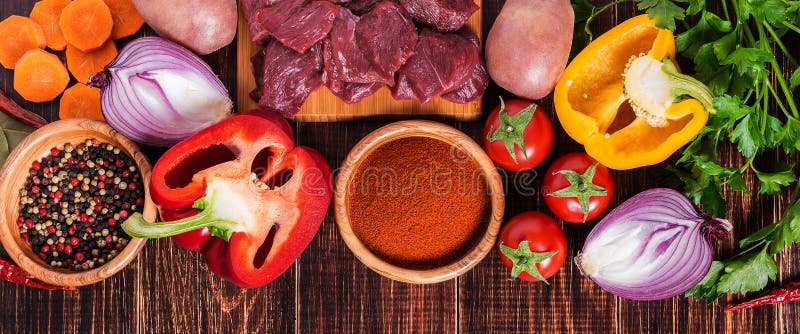 Ingrediënten voor goelasj die koken: ruw vlees, kruiden, kruiden, groenten stock foto Ingrediënten voor goelasj die koken: ruw vlees, kruiden, kruiden, groenten stock foto