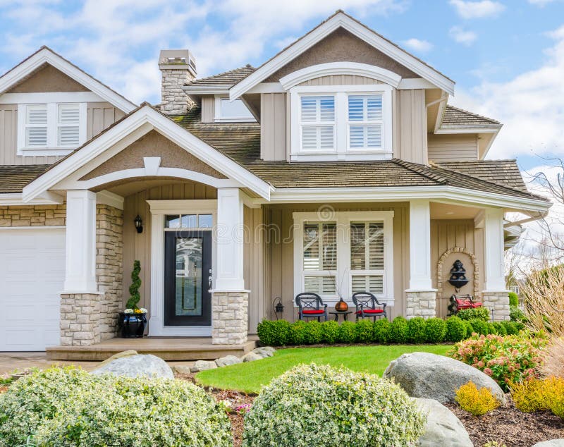 Entrance of a luxury house with beautiful landscaping on a bright, sunny day. Home exterior design. Entrance of a luxury house with beautiful landscaping on a bright, sunny day. Home exterior design.