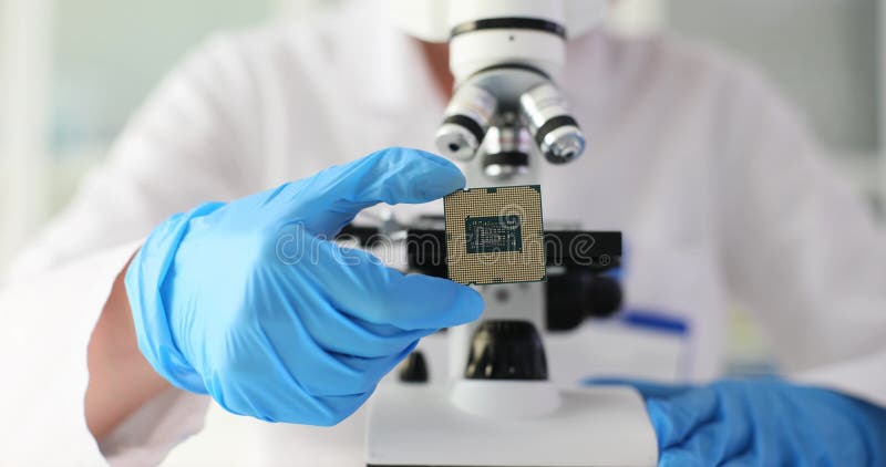 Ingénieur en gant tient microcircuit sur fond de microscope