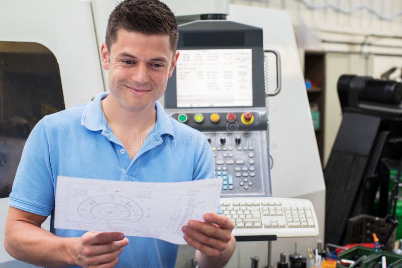 Ingénieur masculin With Technical Drawing actionnant la machine de commande numérique par ordinateur dans le fa photographie stock libre de droits Ingénieur masculin With Technical Drawing actionnant la machine de commande numérique par ordinateur dans le fa photographie stock libre de droits