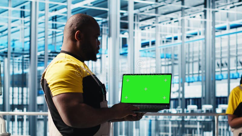 Ingénieur utilisant un ordinateur portable à écran vert dans l'industrie 40 usine banque de vidéos