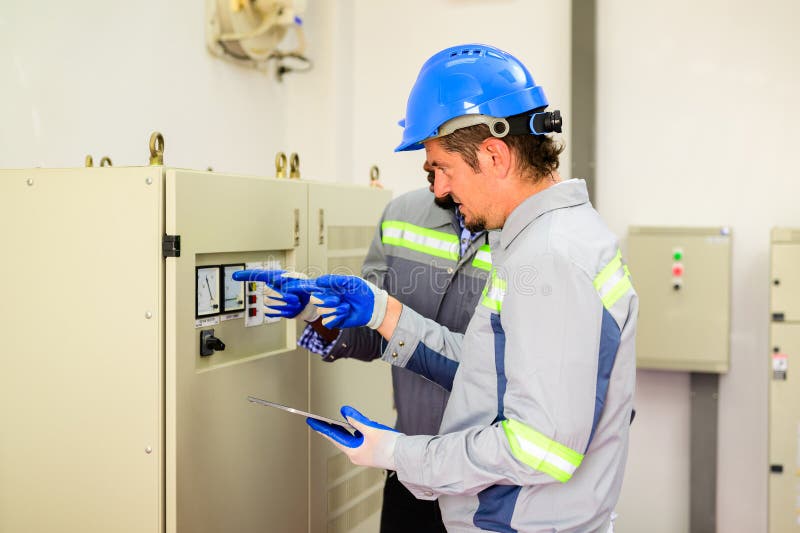 Ingénieurs professionnels en maintenance de panneaux solaires dans une ferme à cellules solaires photos libres de droits