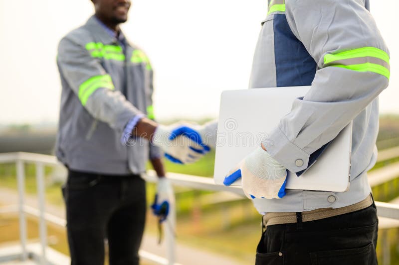 Ingénieurs professionnels en maintenance de panneaux solaires dans une ferme à cellules solaires images stock