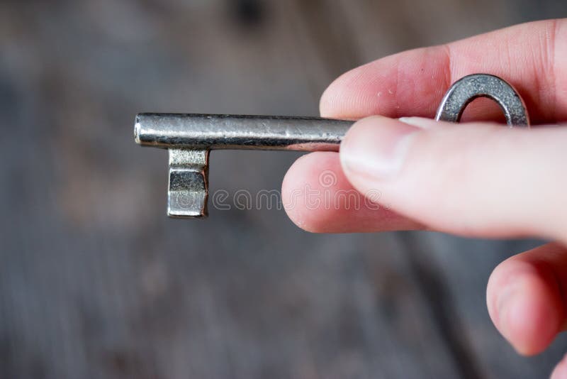 Inheritance concept: Old key in a young male hand royalty free stock photography Inheritance concept: Old key in a young male hand royalty free stock photography