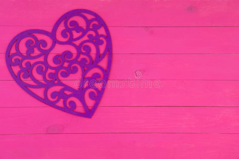 Inimă de filigen violet decorativ pe roz stock image