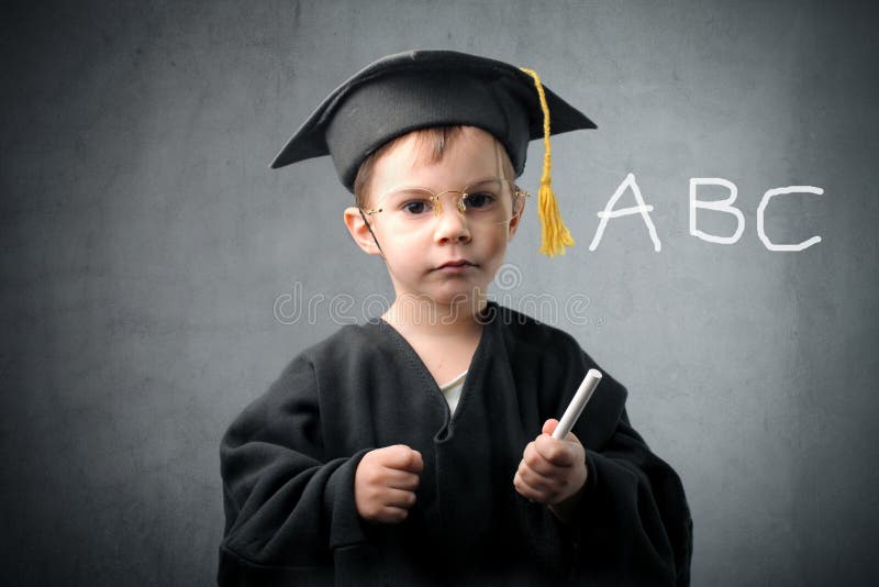 Child in graduate uniform writing the alphabet. Child in graduate uniform writing the alphabet