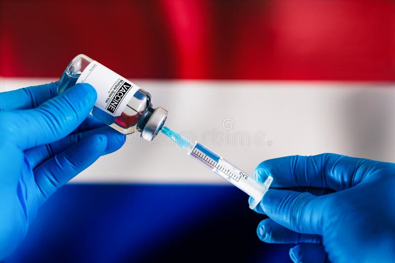 Injektion einer Impfstoffdosis in eine Spritze zur Infektionsprävention vor der niederländischen Flagge stockfoto