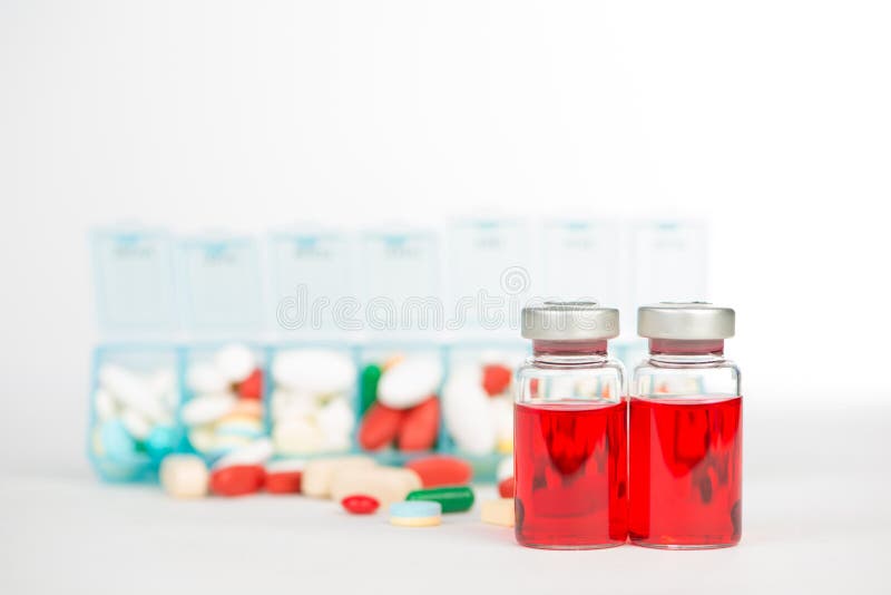 Injektionsmå medicinflaskor och medicin i veckopreventivpiller boxas arkivfoto Injektionsmå medicinflaskor och medicin i veckopreventivpiller boxas arkivfoto