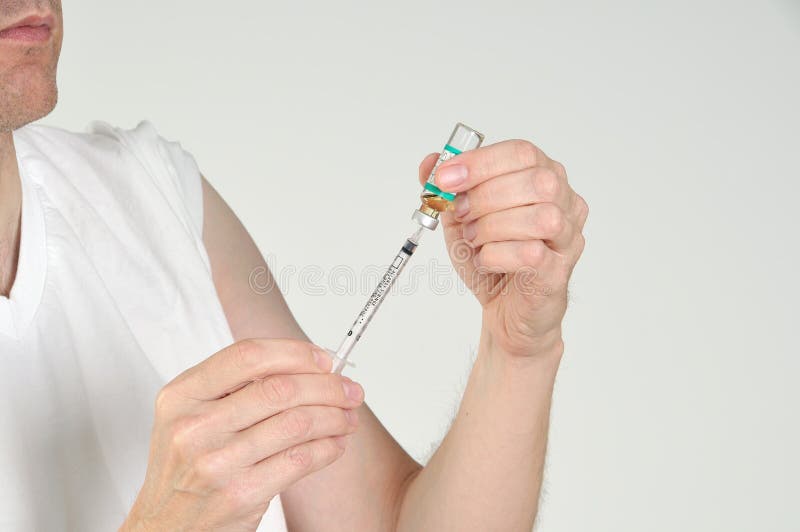 Injection preparation, a man fills a syringe with drugs to inject himself. Injection preparation, a man fills a syringe with drugs to inject himself.