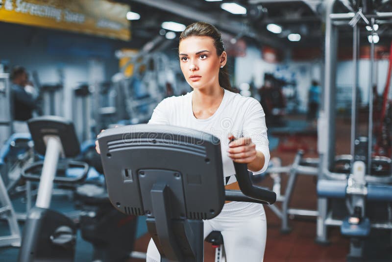 Innenradfahrenfrau, die das Herz Training zuhause radfährt auf Turnhallenfahrrad tut lizenzfreies stockfoto