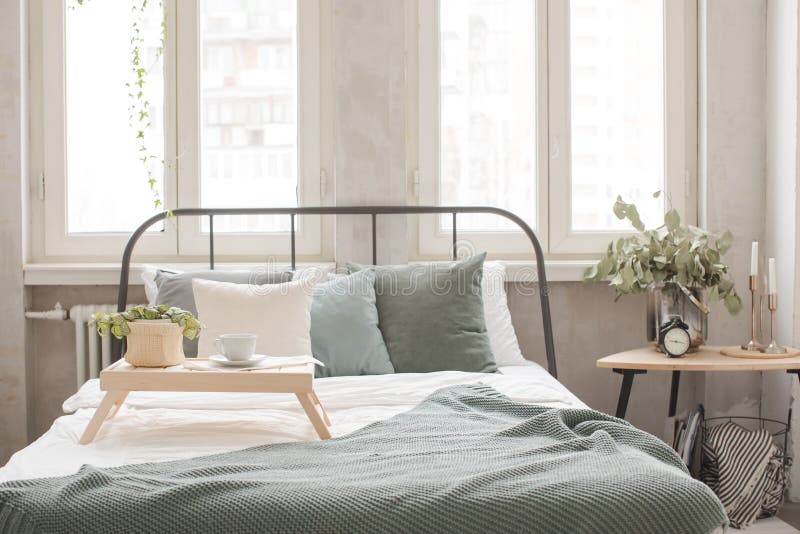 Interior of white and gray cozy bedroom near to white desk with plant. Interior of white and gray cozy bedroom near to white desk with plant