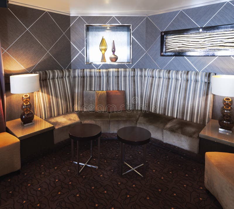 Innenraum mit modernem und stilvollem Design mit Sofaecke mit Kissen und niedrigen zeitgenössischen Stühlen lizenzfreies stockbild Innenraum mit modernem und stilvollem Design mit Sofaecke mit Kissen und niedrigen zeitgenössischen Stühlen lizenzfreies stockbild