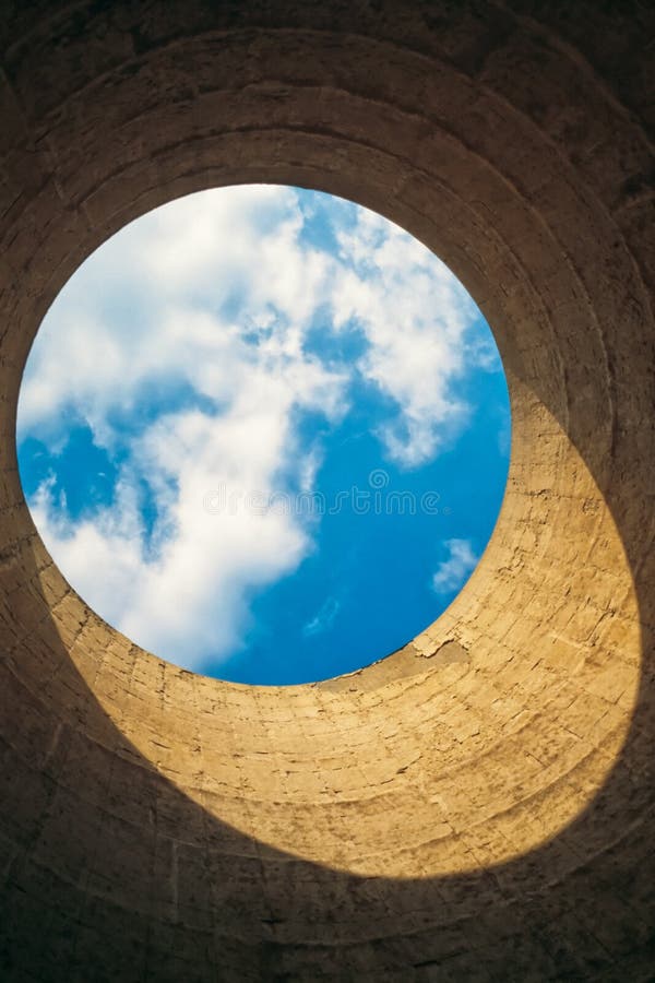 Looking up from the interior of a cooling tower/ chimney showing a blue-white circle of sky resembling our blue planet earth in space. Looking up from the interior of a cooling tower/ chimney showing a blue-white circle of sky resembling our blue planet earth in space.