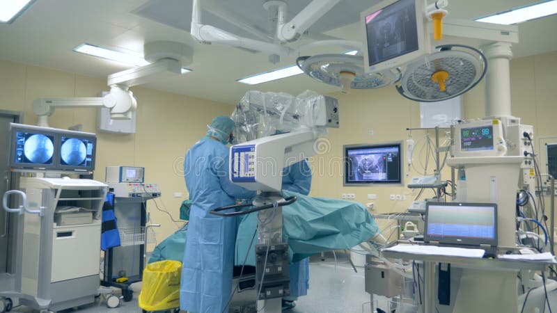 Innovatief geneeskundeconcept Één chirurg gebruikt moderne microscoop en chirurgische robot tijdens een chirurgie bij een kliniek