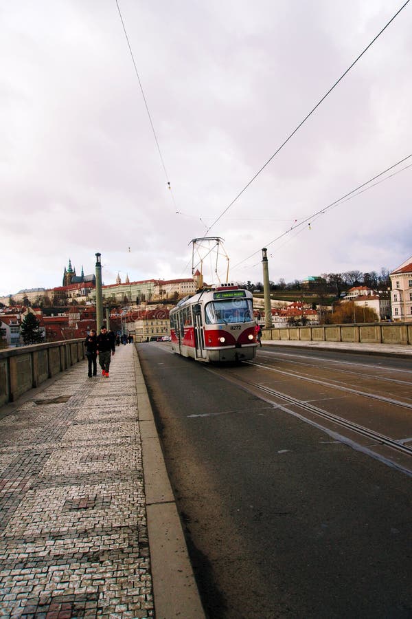 Inquadratura verticale delle persone che passeggiano lungo il ponte delle canne, in una campana di punizione con il tram che passa fotografia stock libera da diritti
