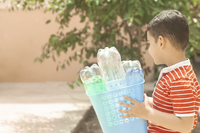 Inquinamento di plastica Il ragazzino ha raccolto le bottiglie di plastica e la tenuta del recipiente di riciclaggio Spazio liber immagine stock Inquinamento di plastica Il ragazzino ha raccolto le bottiglie di plastica e la tenuta del recipiente di riciclaggio Spazio liber immagine stock