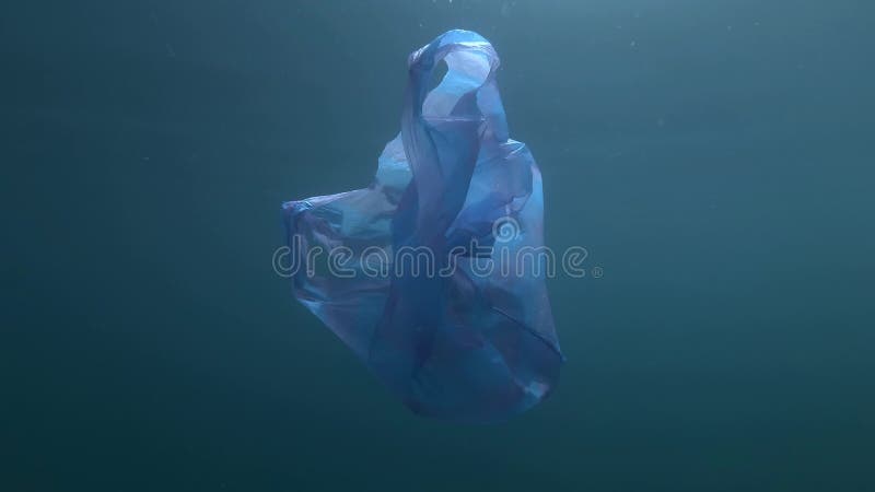 Inquinamento di plastica, sacchetto di plastica blu usato che lentamente gocciola sott'acqua Spari sott'acqua, detriti di plastic