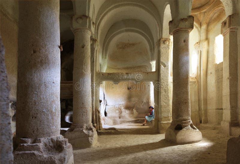 Inre av kolonnkorridoren av den gamla underjordiska kyrkan som snidas in i sandstenen, vaggar royaltyfri foto Inre av kolonnkorridoren av den gamla underjordiska kyrkan som snidas in i sandstenen, vaggar royaltyfri foto