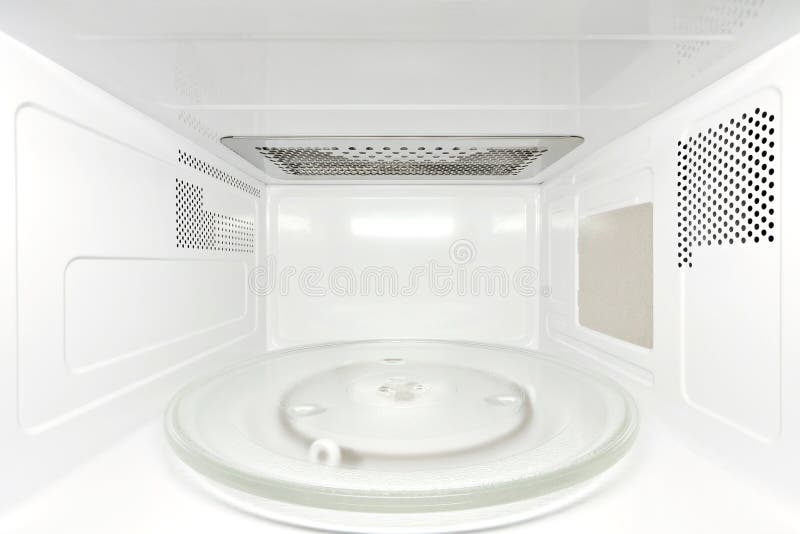 Front view inside white, clean, opened empty microwave oven interior with forced perspective. Front view inside white, clean, opened empty microwave oven interior with forced perspective