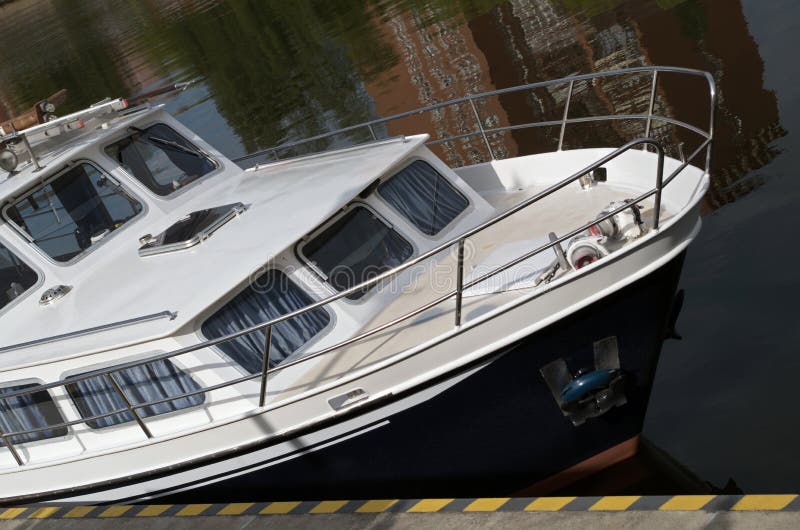 Inredd i kustfritidsbåt med vitt däck och svart skrov arkivbilder