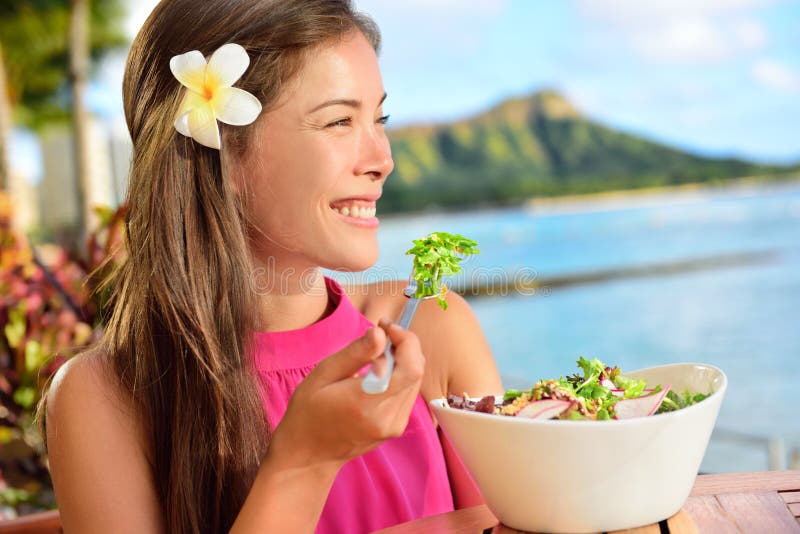 Insalata che mangia donna in buona salute al ristorante in Hawai immagini stock Insalata che mangia donna in buona salute al ristorante in Hawai immagini stock