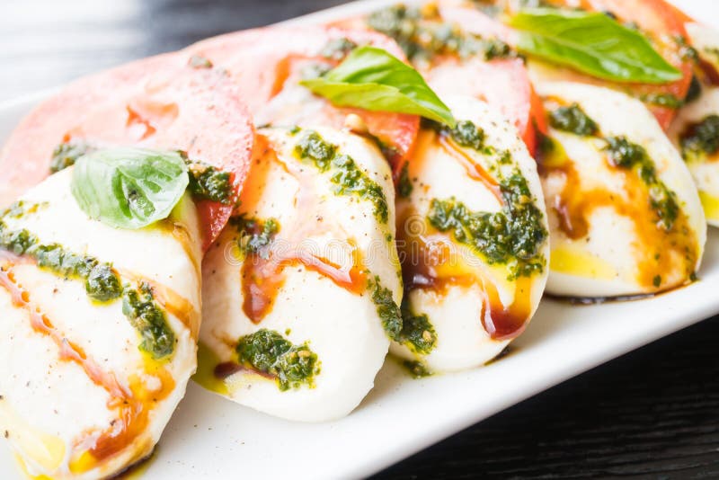 Insalata del formaggio della mozzarella e del pomodoro in piatto bianco fotografia stock libera da diritti Insalata del formaggio della mozzarella e del pomodoro in piatto bianco fotografia stock libera da diritti