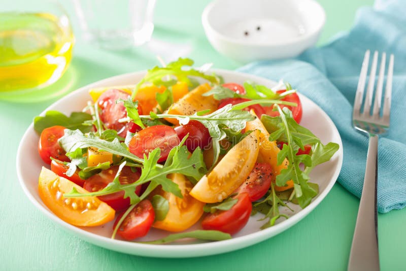 Insalata del pomodoro con la rucola sopra fondo verde immagine stock Insalata del pomodoro con la rucola sopra fondo verde immagine stock