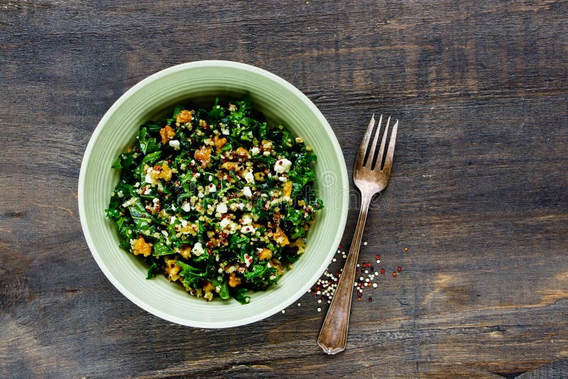 Healthy detox salad bowl on wooden background. Raw kale and quinoa salad with feta cheese and walnut flat lay. Top view. Clean eating, dieting, vegetarian food concept. Healthy detox salad bowl on wooden background. Raw kale and quinoa salad with feta cheese and walnut flat lay. Top view. Clean eating, dieting, vegetarian food concept