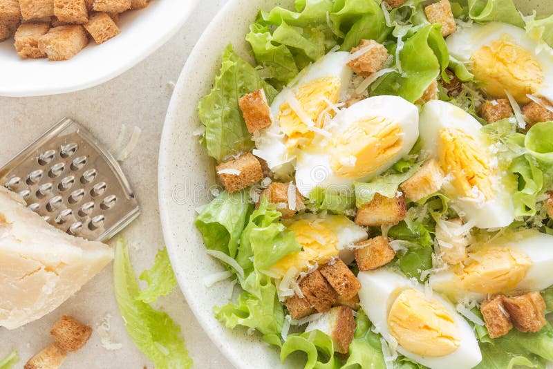 Insalata di Caesar con le uova, la lattuga ed il parmigiano sul piatto fotografia stock Insalata di Caesar con le uova, la lattuga ed il parmigiano sul piatto fotografia stock