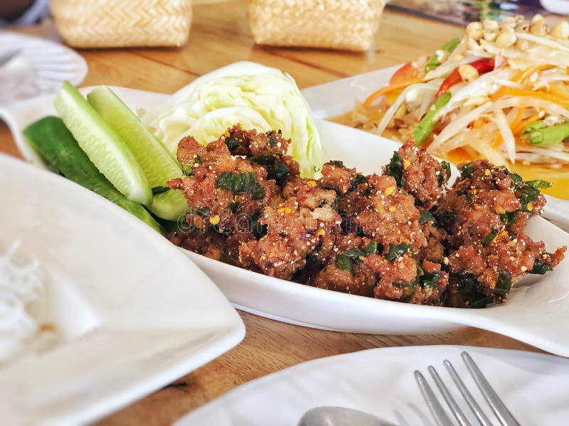 Insalata di maiale macinata, fritta, con riso e verdure appiccicose, servita con insalata di papaya thai, famoso alimento tradizi fotografia stock Insalata di maiale macinata, fritta, con riso e verdure appiccicose, servita con insalata di papaya thai, famoso alimento tradizi fotografia stock